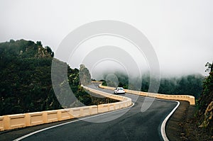 Car is on winding road in mist in Tenerife