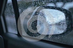 Car window with rain drops on glass or the windshield,Blurred traffic on rainy day