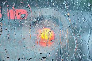 Car window on the strret during heavy rain with blurry city lights