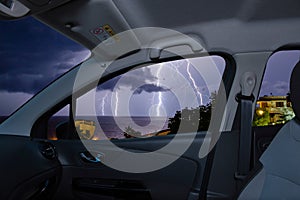 Car window with view of lightning storm over the sea photo