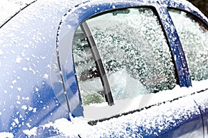 Car windows and wipers covered with snow in winter