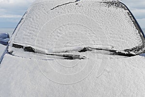 Car windshield covered with snow