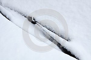 Car windshield covered with snow. car detail in winter. Layout for decor and design at transportation.