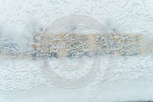 Car windshield covered in snow with out of focus background