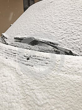 A car windshield covered with snow in winter