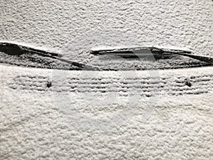 A car windshield covered with snow in winter