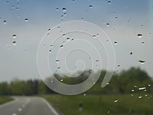 Car windshield with rain drops during drive