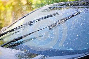 Car windshield with rain drops and frameless wiper blade