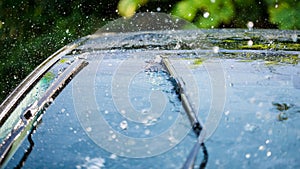 Car windshield with rain drops and frameless wiper blade