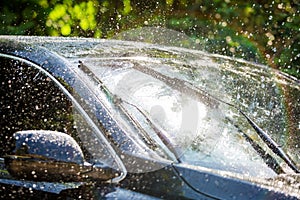 Car windshield with rain drops and frameless wiper blade