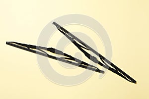 Car windshield wipers on beige background, flat lay