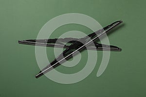 Car windshield wipers on dark green background, flat lay