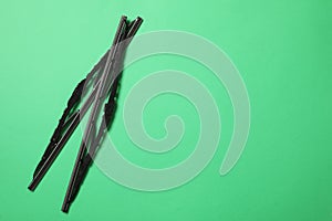 Car windshield wipers on green background, flat lay. Space for text