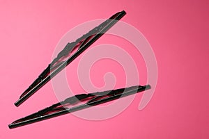 Car windshield wipers on pink background, flat lay