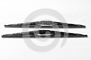 Car windshield wipers on white wooden background, flat lay