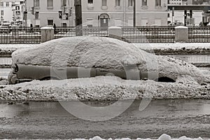 Car on winter road covered with snow side view. Vehicle on snowy alley in the morning after snowfall in city. A street