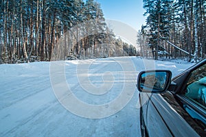 Car on a winter road in the forest