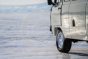A car with winter tire parked on ice at frozen lake Baikal