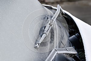 Car wiper and front window covered with frost. Wiper frozen.