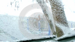 Car wipers clean the windshield from snow in winter-view from inside the cabin. Dangerous weather conditions, road safety.