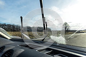 Car wipers clean windshields when driving in sunny weather.