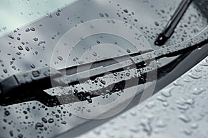 Car wipers and water drops on windshield glass, closeup
