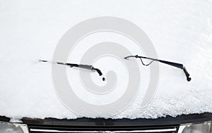 Car wipers and windscreen covered with snow