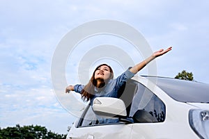 Car woman on road on road trip waving happy smiling .