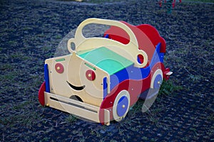 The car is wooden bright red blue with a smile. Playgrounds,