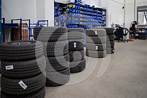 In car workshop there are many stacked car tires