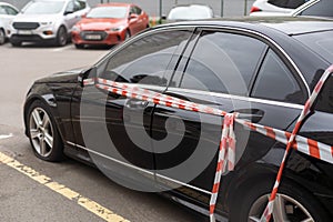 A car is wrapped in safety tapes.