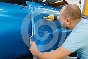Car wrapper installs protective vinyl foil or film