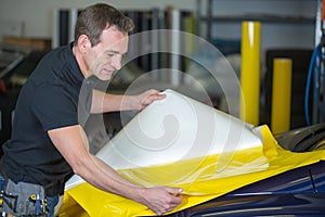 Car wrapper preparing foil to wrap a vehicle