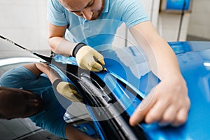 Car wrapping, man cuts protective foil or film