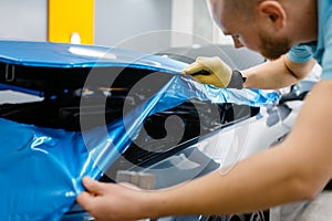 Car wrapping, man cuts protective foil or film