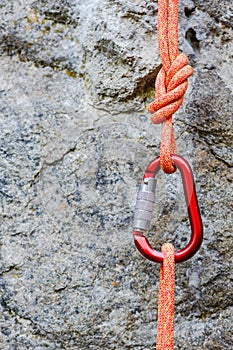 Carabiner with rope on rocky background