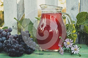 Carafe of red wine with a bunch of grapes