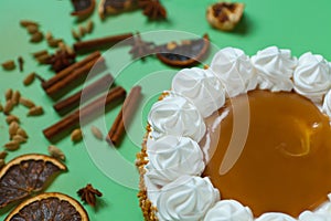 Caramel cake with nuts and caramel sauce glaze. whipped cream with cinnamon. rounded tart or pie