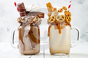 Caramel and chocolate crazy freakshake milkshakes with brezel waffles, popcorn, marshmallow, ice cream and whipped cream.