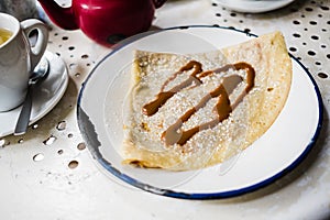 a caramel crepe on a table in a coffee shop