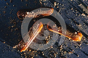 Caramel eclairs with golden sprinkles on dark bakcground.