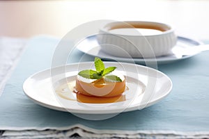 caramel flan quivering on a white dish with caramel sauce