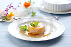 caramel flan quivering on a white dish with caramel sauce