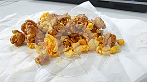 Caramel-flavored popcorn snacks on a tissue at the table