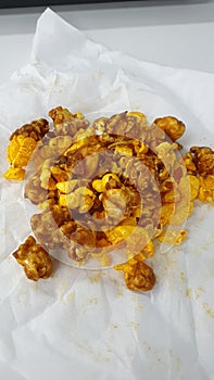 Caramel-flavored popcorn snacks on a tissue at the table