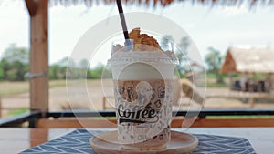 Caramel milkshake topping with cereals cornflake in a plastic glass