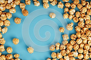 Caramel popcorn by a ripple on a blue background  in the form of a frame photo