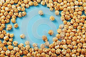 Caramel popcorn by a ripple on a blue background  in the form of a frame photo