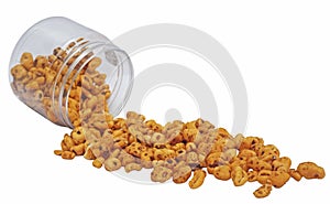 Caramel Puff Wheat Cereal Spilling Out of Plastic Jar isolated on White Background