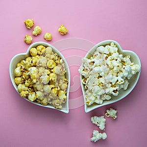 Caramel and salty popcorn on a pink background in white heart plates.